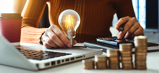 business man hand holding lightbulb with using smartphone and ca