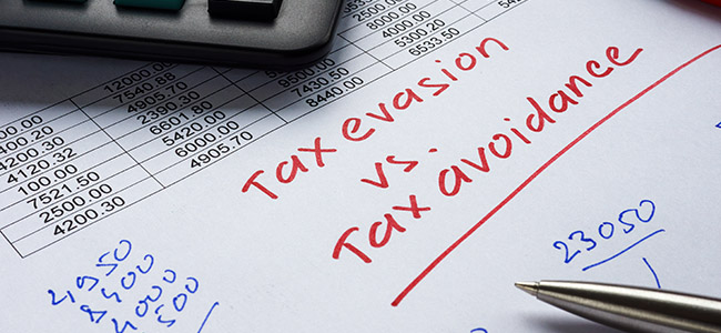 Handwritten inscription tax evasion vs tax avoidance on a piece of paper.