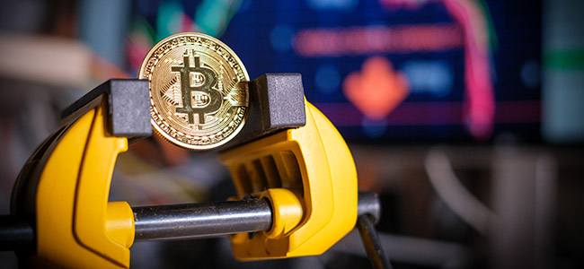 bitcoin coin is clamped in a vice
